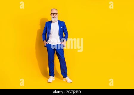 Full length body size photo of man wearing blue suit smiling isolated on bright yellow color background with copyspace Stock Photo