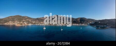 Sifnos island, Platys gialos aerial drone panoramic view from the sea. Greece Cyclades. Boats moored at calm Aegean Sea, clear blue sky background. Su Stock Photo