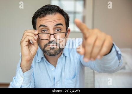 Man with a poor eyesight trying to adjust his glasses to see better Stock Photo