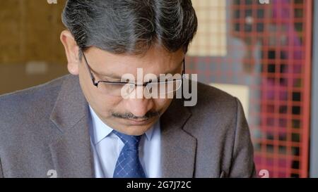Closeup shot of an Indian successful businessman with eyeglasses Stock Photo