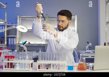 Serious young male scientist working in a pharma or biotech scientific laboratory Stock Photo