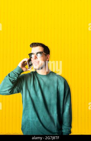 Portrait of a young handsome man smiling using his smartphone on the street Stock Photo