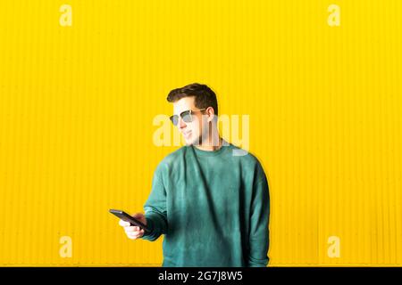 Portrait of a handsome young man using his mobile phone on the street Stock Photo