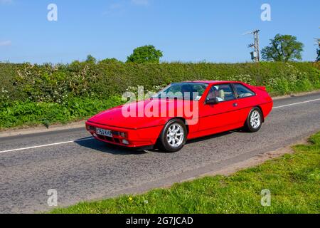 1987 80s eighties red M50 Lotus Excel 5 speed manual, 2174cc,  3-door fastback coupe 2+2 super-sports car en-route to Capesthorne Hall classic May car show, Cheshire, UK Stock Photo