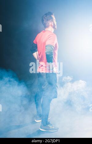 Side back view of an adult male with hands in waist looking forward. Stock Photo