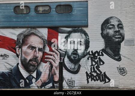 London, UK. 14th July, 2021. The mural of England football manager Gareth Southgate and players Harry Kane and Raheem Sterling, with the words 'You Did Us Proud', is seen on a wall at Vinegar Yard in London. The mural was painted by MurWalls following the England football team's achievement of making it to the final of Euro 2020. Credit: SOPA Images Limited/Alamy Live News Stock Photo