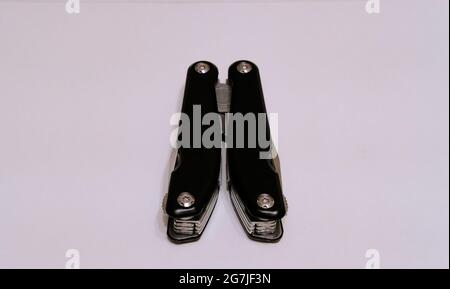 Black multitool folded on a white background Stock Photo