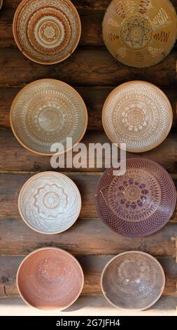 Eight ceramic plates with patterns on a wicker wall background Stock Photo