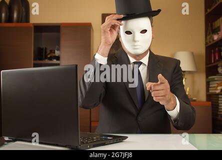 businessman disguised with a mask and hat telecommuting from home due to covid restrictions Stock Photo