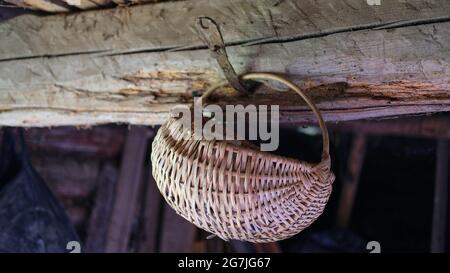 Wicker wooden basket hanging on a log Stock Photo