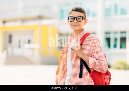 Portrait of a cute boy in glasses who is going to school with his school backpack, Student boy on the way to school, Learning for children Stock Photo