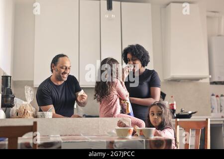 Cute view of a family having fun eating in the kitchen at home Stock Photo