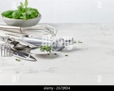 various cooking utensils on white kitchen table Stock Photo