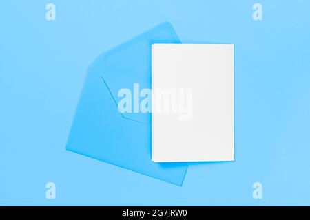 Blank white card with blue envelope isolated on blue background. Template or mock up. Banner with copy space Stock Photo