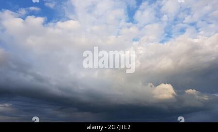 Blue sky with white grey clouds in overcast day before rain. Stock Photo
