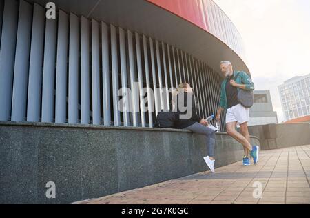 Active mature couple, man and woman in sportswear having a conversation outdoors while waiting together for workout Stock Photo