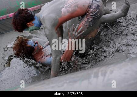 July 15, 2021-Boryeong, South Korea-A Visitors  enjoying wrestle in the mud pool during an Annual Boryeong Mud Festival at Daecheon Beach in Boryeong, South Korea. The mud, which is believed to have beneficial effects on the skin due to its mineral content, is sourced from mud flats near Boryeong and transported to the beach by truck. Stock Photo