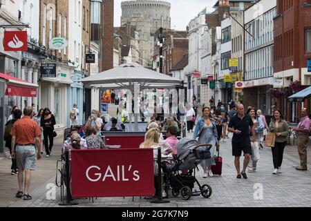 Windsor, UK. 14th July, 2021. Local residents and visitors shop and relax in the town centre ahead of the lifting of legal restrictions on social contact. The UK government announced on 12th July that England will move to the final stage of easing Covid-19 restrictions on 19th July but they also advised the public to exercise caution given that the current wave driven by the Delta variant is not expected to peak until mid-August. Credit: Mark Kerrison/Alamy Live News Stock Photo