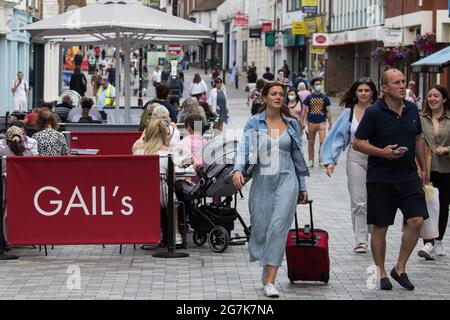 Windsor, UK. 14th July, 2021. Local residents and visitors shop and relax in the town centre ahead of the lifting of legal restrictions on social contact. The UK government announced on 12th July that England will move to the final stage of easing Covid-19 restrictions on 19th July but they also advised the public to exercise caution given that the current wave driven by the Delta variant is not expected to peak until mid-August. Credit: Mark Kerrison/Alamy Live News Stock Photo