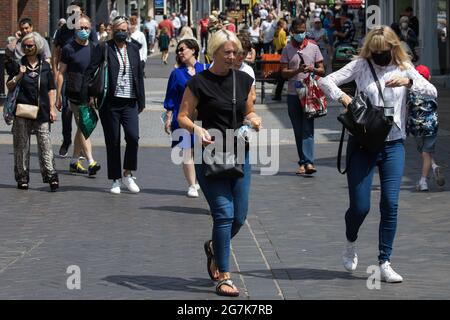 Windsor, UK. 14th July, 2021. Local residents and visitors shop in the town centre, some choosing to wear face coverings outside, ahead of the lifting of legal restrictions on social contact. The UK government announced on 12th July that England will move to the final stage of easing Covid-19 restrictions on 19th July but they also advised the public to exercise caution given that the current wave driven by the Delta variant is not expected to peak until mid-August. Credit: Mark Kerrison/Alamy Live News Stock Photo