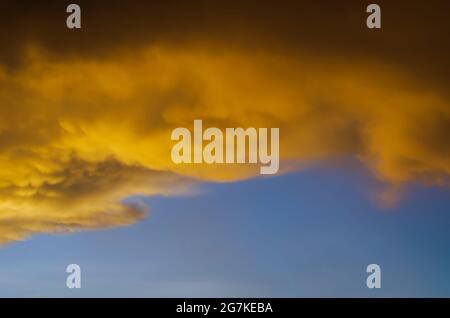 Yellow cloud from sunshine in evening with blue sky when start to rain in monsoon season. Stock Photo