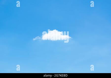 Single white cloud stay alone in bright blue sky in summertime. Stock Photo