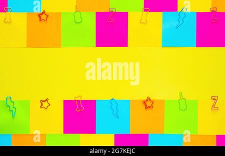 Colorful sticky note papers with paper clip on yellow background. Stock Photo