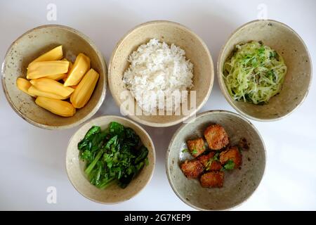 Top view vegan meal from daily dish menu for Vietnamese lunch with fried vegetable protein, kale soup, chayote and jackfruit on white background Stock Photo