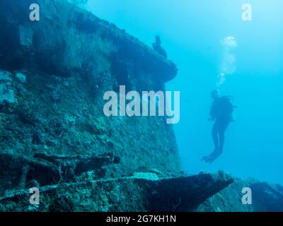 Silhouette of a diver near the wheelhouse of a sunken ship at the bottom of the Indian Ocean Stock Photo