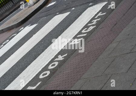 A zebra crossing in London depicting look right with arrows Stock Photo