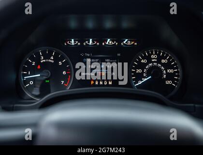 Speedometer of a new modern car with an integrated fuel gauge in the tank with blue arrows. Starting engine, with warning lights on. Stock Photo