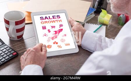 Sales growth concept shown on a tablet held by a man Stock Photo