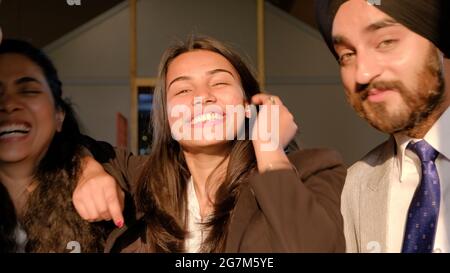 Young Indian co-workers wearing suits and smiling Stock Photo