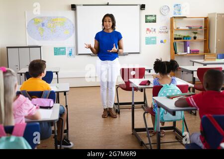 African american female teacher teaching students in the class at elementary school Stock Photo