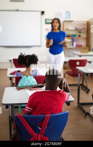 African american female teacher teaching students in the class at elementary school Stock Photo