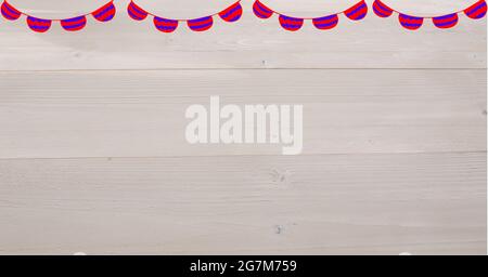 Digitally generated image of red and blue bunting flag decorations against wooden background Stock Photo