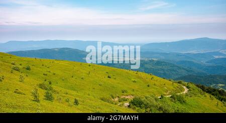 country road through the hill. mountain landscape in morning light. blue sky with clouds on a horizon above the distant ridge. rural valley between th Stock Photo