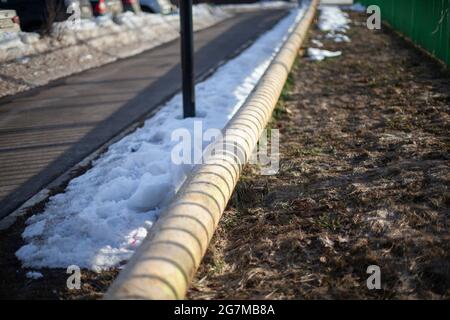 Heating pipe in winter in Russia. Heating main on the street. Means of communication in the city. Hot water supply. Stock Photo