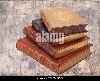Very old antiquarian books stacked on side in leather covers on a brown background Stock Photo