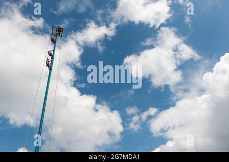 Papantla, Mexico - May 21, 2014: A group of voladores (flyers) climbing the pole to perform the traditional Danza de los Voladores (Dance of the Flyer Stock Photo