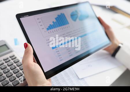 Woman holding digital tablet with charts in her hands closeup Stock Photo