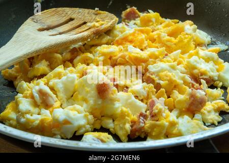 Scrambled eggs with bacon in a pan, close up Stock Photo