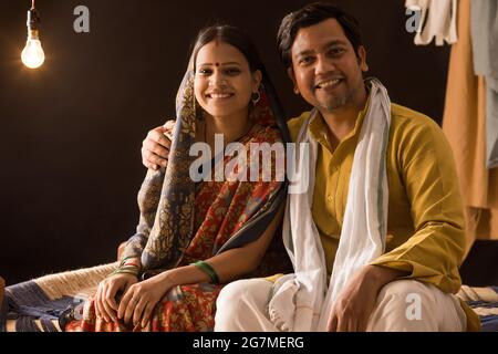 A RURAL COUPLE SITTING TOGETHER HAPPILY Stock Photo