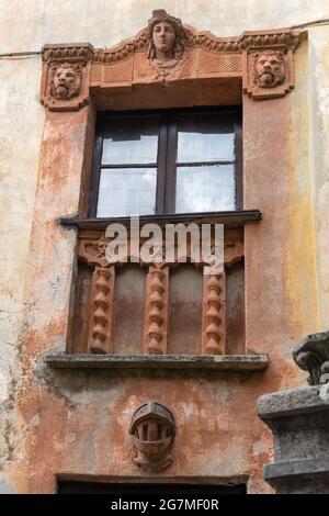 detail of picturesque decorated window of old building at village on lake shore , shot in summer time at Torno, Como, Italy Stock Photo