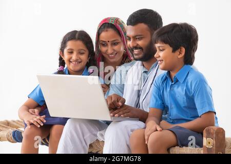 PORTRAIT OF A RURAL FAMILY USING A LAPTOP Stock Photo