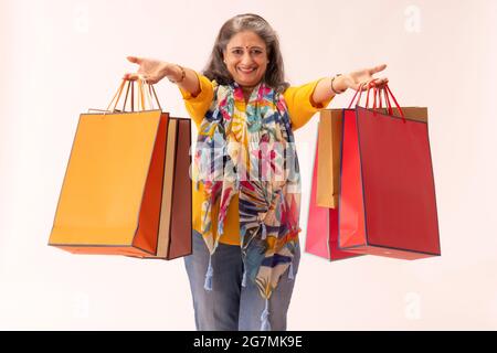 A HAPPY WOMAN SHOWING HER SHOPPING BAGS IN FRONT OF CAMERA Stock Photo