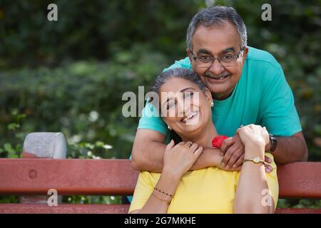 A HAPPY COUPLE EMBRACING EACH OTHER AND POSING IN FRONT OF CAMERA Stock Photo