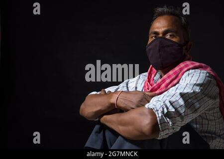 PORTRAIT OF A LABOURER LOOKING AT CAMERA WEARING FACE MASK Stock Photo