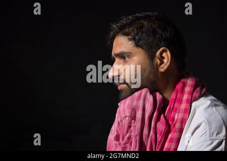 A TIRED LABOURER LOOKING AWAY AND THINKING Stock Photo