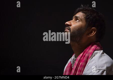 A LABOURER SITTING ALONE AND LOOKING ABOVE Stock Photo